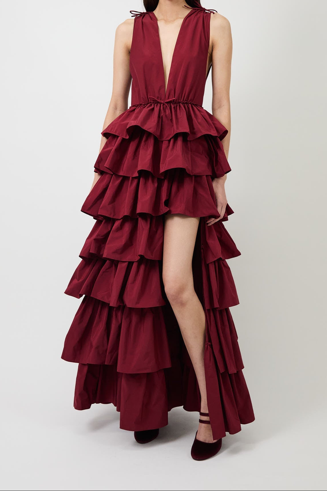 Women's burgundy deep-V evening gown with a high slit.