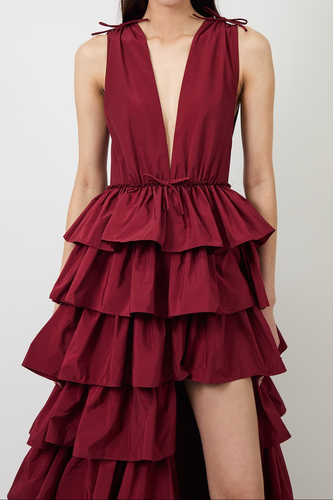Women's burgundy deep-V evening gown with a high slit.